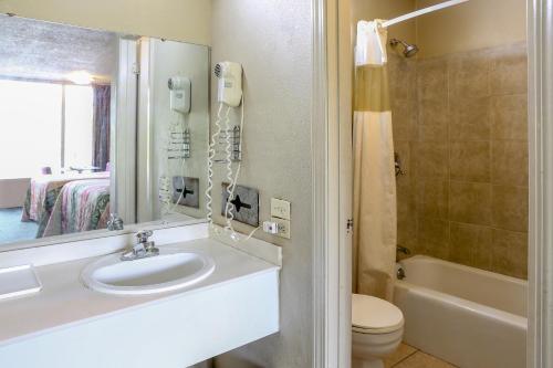 a bathroom with a sink and a toilet and a tub at SPRINGWOOD HOTEL, Opelika I-85 Columbus Pkwy in Opelika