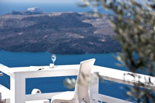 a white table with a glass of wine on it at Hotel Thireas in Fira
