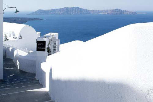 a view of the ocean from the side of a white building at Hotel Thireas in Fira