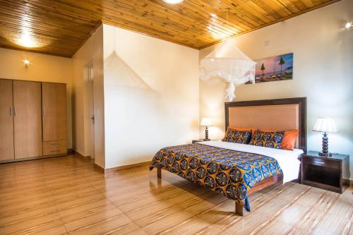 a bedroom with a bed and a wooden ceiling at High Ground Villa Ltd in Kigali