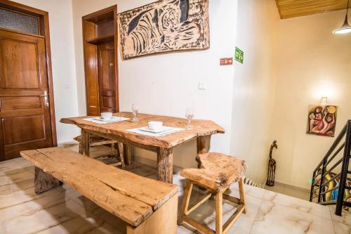 a dining room with a wooden table and a bench at High Ground Villa Ltd in Kigali
