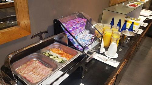 アルカラ・デ・エナレスにあるPCM Forum Alcaláの食べ物と飲み物のトレイが2つ置かれたキッチンカウンター