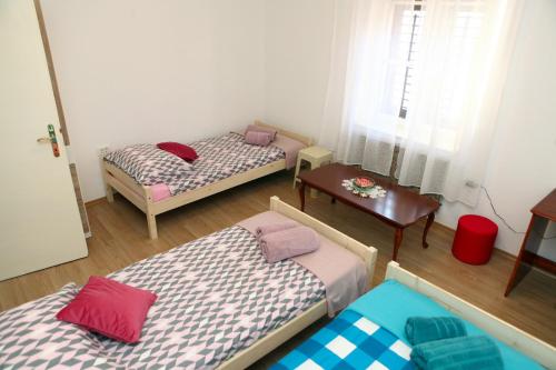 a room with two beds and a table and a window at Apartma Grof in Koper