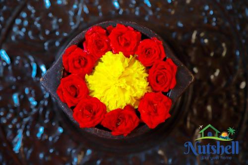 a bouquet of red and yellow roses in a vase at Nutshell-Airport Retreat by the Sea in Trivandrum