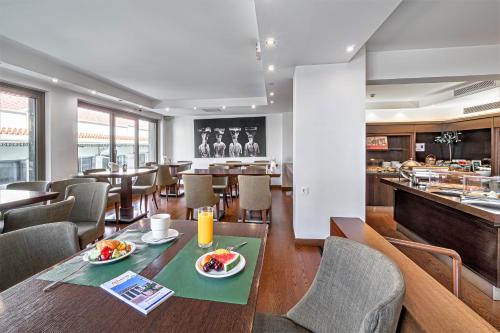 a dining room with a table and chairs and a restaurant at Plaka Hotel in Athens