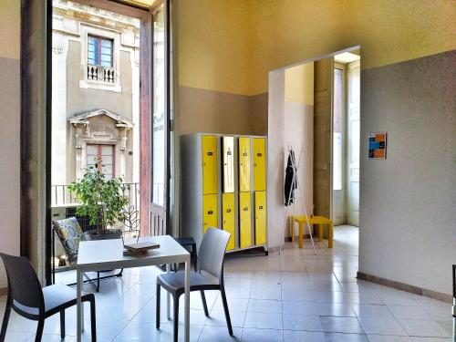 a dining room with yellow cabinets and a table and chairs at Ostello degli Elefanti in Catania