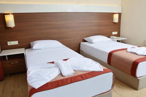 a hotel room with two beds with white towels at Sunway Club Otel in Marmaris