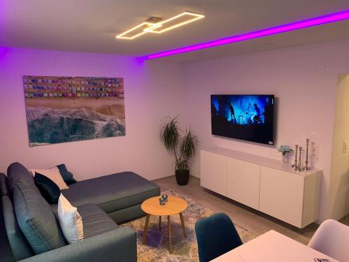 ein Wohnzimmer mit einem Sofa und einem Flachbild-TV in der Unterkunft Natal Gian in Ischgl