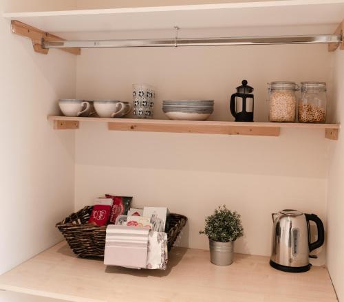 a shelf in a kitchen with bowls and other kitchen items at A Stay On The Brae in Edinburgh