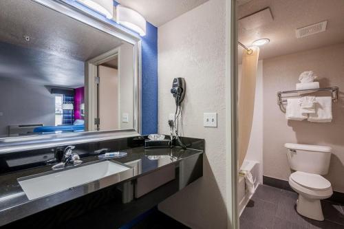 ein Badezimmer mit einem Waschbecken, einem WC und einem Spiegel in der Unterkunft Stratford House Inn in Edmond