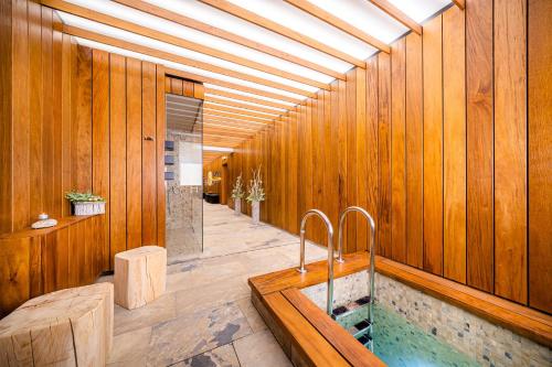 a bathroom with a tub in a wooden wall at Hotel Akademie in Chocerady