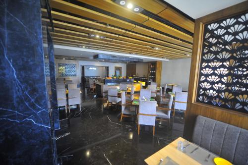 a restaurant with a dining room with tables and chairs at Pipul Padmaja Premium Hotel in Bhubaneshwar