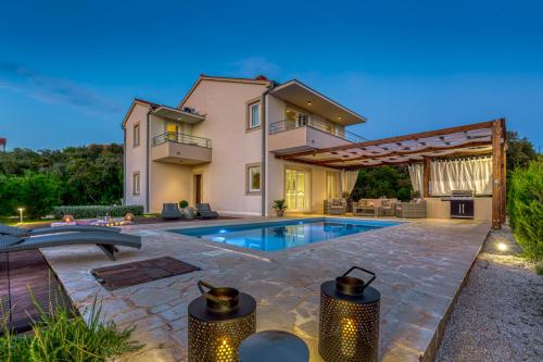 a villa with a swimming pool and a house at Villa Gellia in Ugljan