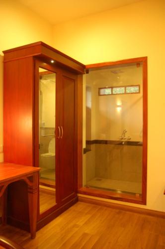 a wooden cabinet with a glass door in a room at The Villa Romantica in Nedumbassery