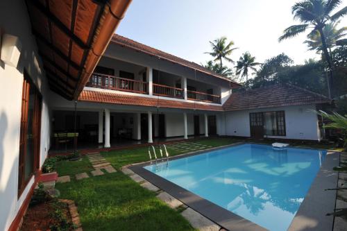 - une vue extérieure sur une maison avec une piscine dans l'établissement The Villa Romantica, à Nedumbassery