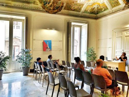 a group of people sitting in chairs in a room at Ostello degli Elefanti in Catania