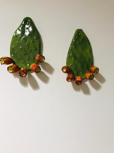two green cactus earrings on a white background at Co Mó - Camera a Sud - Affittacamere in Mesagne