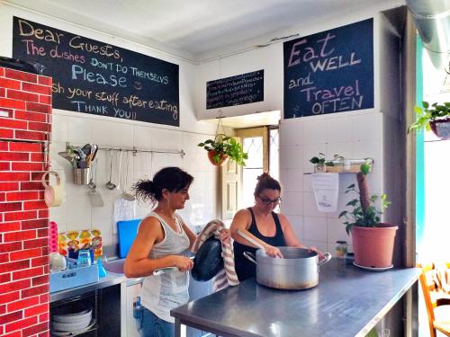 three women standing in a kitchen preparing food at Ostello degli Elefanti in Catania