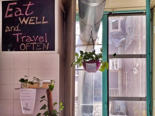a window with a sign that says eat well and travel often at Ostello degli Elefanti in Catania