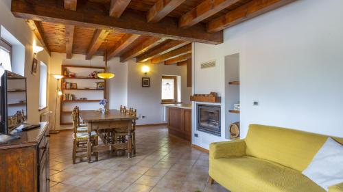 ein Wohnzimmer mit einem Tisch und einem gelben Sofa in der Unterkunft Albergo Diffuso Ravascletto in Ravascletto