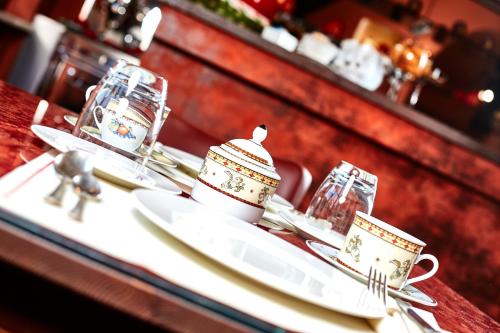 a table with two plates and cups and utensils at Albergo Trattoria Il Leone in Pomponesco