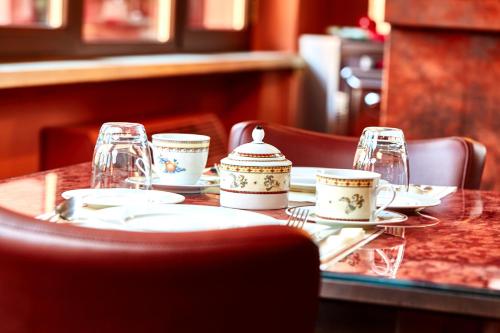 a table with plates and cups and glasses on it at Albergo Trattoria Il Leone in Pomponesco
