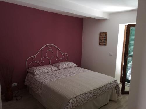 a bedroom with a bed with a purple wall at Agriturismo LaValleggia in Tovo San Giacomo