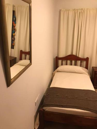 a bedroom with a bed with a mirror on the wall at Cerro del sol, habitaciones privadas in Salta