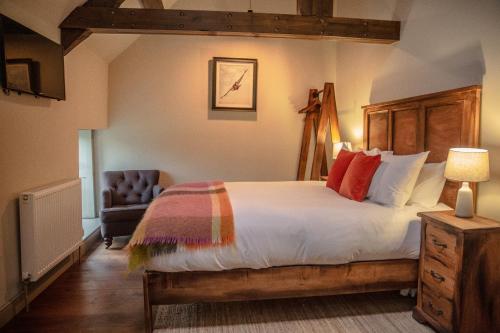 a bedroom with a large bed and a chair at Killingworth Castle in Woodstock