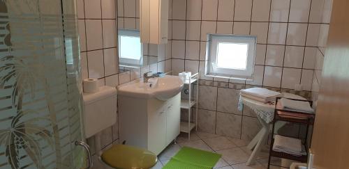 un piccolo bagno con lavandino e doccia di Apartments Vila Lavanda a Omišalj (Castelmuschio)