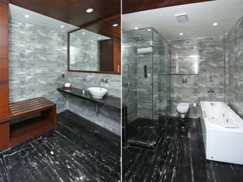 La salle de bains est pourvue d'une douche, d'un lavabo et d'une baignoire. dans l'établissement OYO 1236 Elite Residence, à Manado
