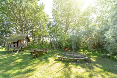 um parque com mesas de piquenique e um parque infantil em Ferienwohnungen im Reetdachhaus em Ummanz