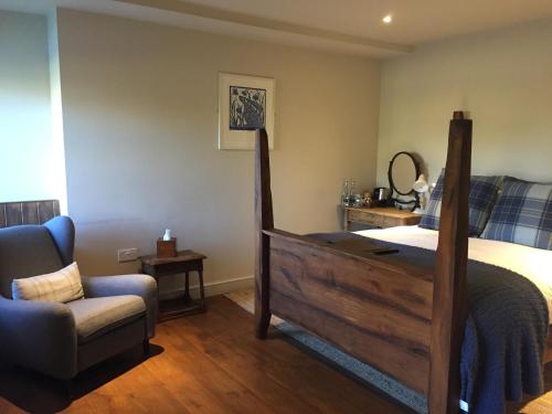 a bedroom with a large bed and a chair at Killingworth Castle in Woodstock