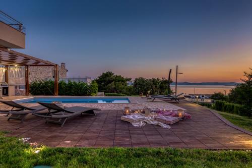 a patio with a table next to a swimming pool at Villa Gellia in Ugljan