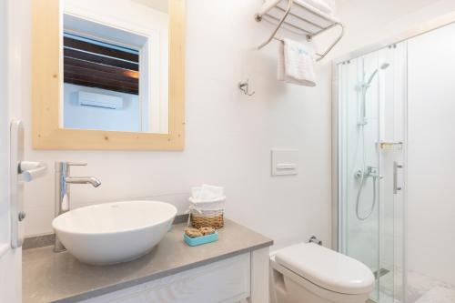 a white bathroom with a sink and a toilet at Monza House Otel in Siğacık