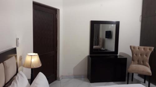 a bedroom with a mirror and a chair at MaryLeena Hotel Gulberg in Gulberg