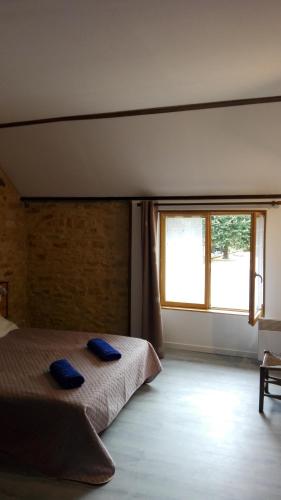 une chambre avec un lit avec deux oreillers bleus dessus dans l'établissement Au Tilleul, à Archignac