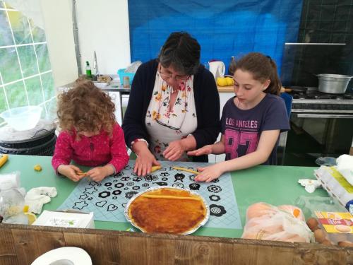 a woman and two children standing around a table with a pie at Lago Secco Bed & Breakfast Country House in Accumoli