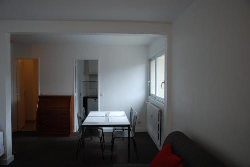 ein Esszimmer mit einem Tisch und Stühlen in einem Zimmer in der Unterkunft Appartements Paris Boulogne in Boulogne-Billancourt