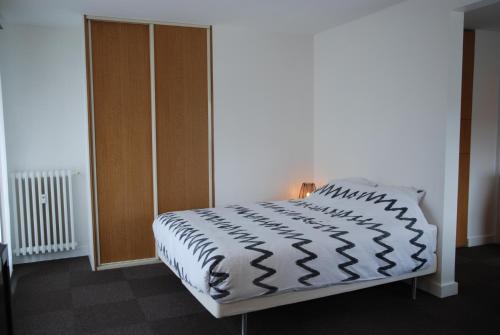a bedroom with a bed and a wooden cabinet at Appartements Paris Boulogne in Boulogne-Billancourt