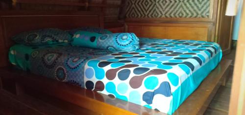 een blauw en wit bed met kussens erop bij Rammang Rammang Eco Lodge in Baloci