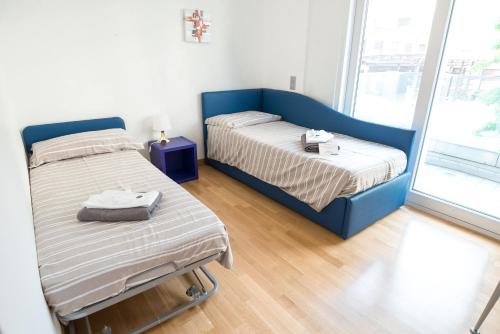 a small bedroom with two beds and a window at Prestige Apartments by Quokka 360 - spacious flats with terraces in Lugano