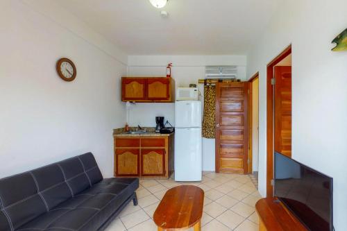 a living room with a couch and a kitchen at Mayan Falls in Caye Caulker