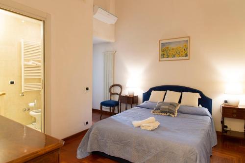 a bedroom with a blue bed and a bathroom at Sistina 138 Luxury Home in Rome