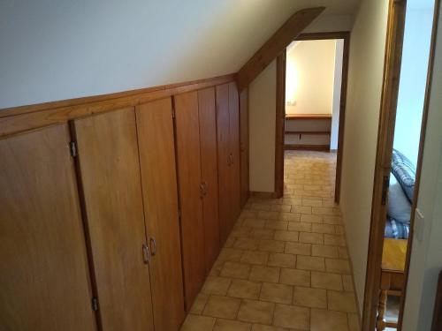 a hallway with wooden cabinets and a staircase at Le Botcol in Plouguernével