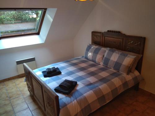 a bedroom with a bed with two bags on it at Le Botcol in Plouguernével
