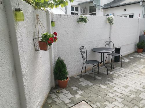 a patio with a table and chairs and plants at Maison 33 in Bucharest