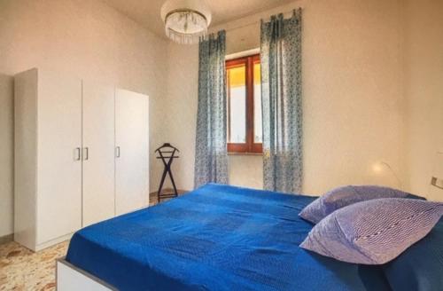 a bedroom with a blue bed with two pillows at Casa Liliana in Marsala