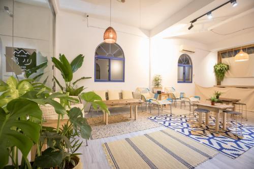 a living room with tables and chairs and plants at Island River in Green Island