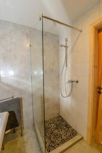 a shower with a glass door in a bathroom at Vivaldi Lake House in Meteliai